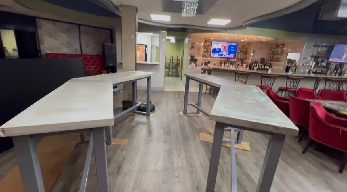 The finished lounge with wood flooring, high tables, red banquettes and a stocked bar