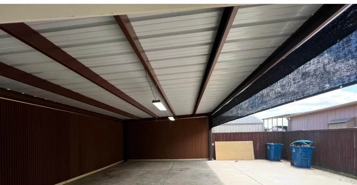 The completed covered parking structure with a white metal roof, brown beams and wood-look wall panels